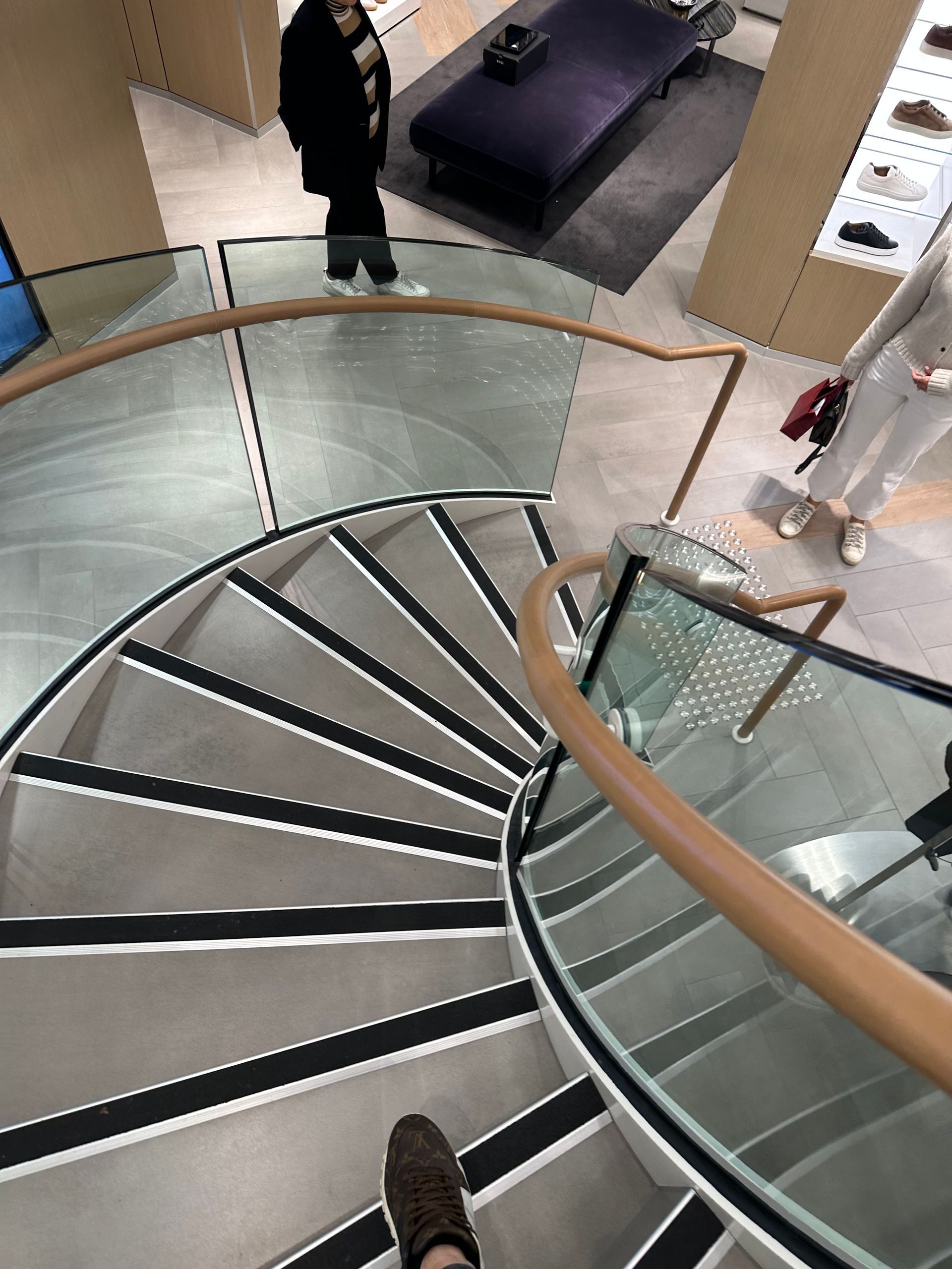 A Wooden Staircase With a Glass Railing in a Room — All Glass Balustrading Systems in Wetherill Park, NSW