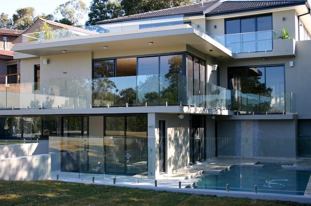 A Large House With a Swimming Pool in Front of It — All Glass Balustrading Systems in Wetherill Park, NSW