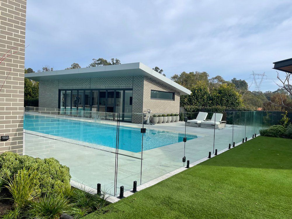 There is a Large Swimming Pool in the Backyard of a House — All Glass Balustrading Systems in Coogee, NSW