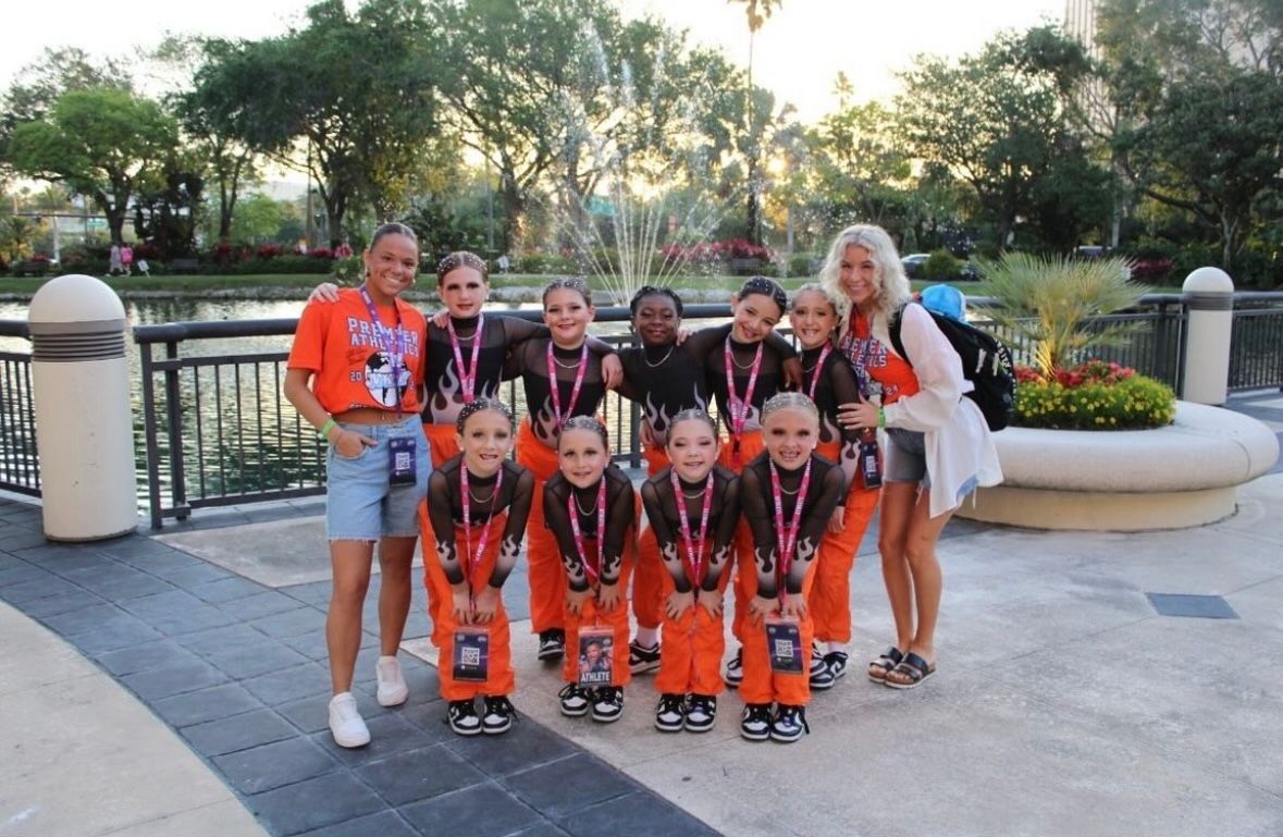A group of young girls posing for a picture with medals around their necks