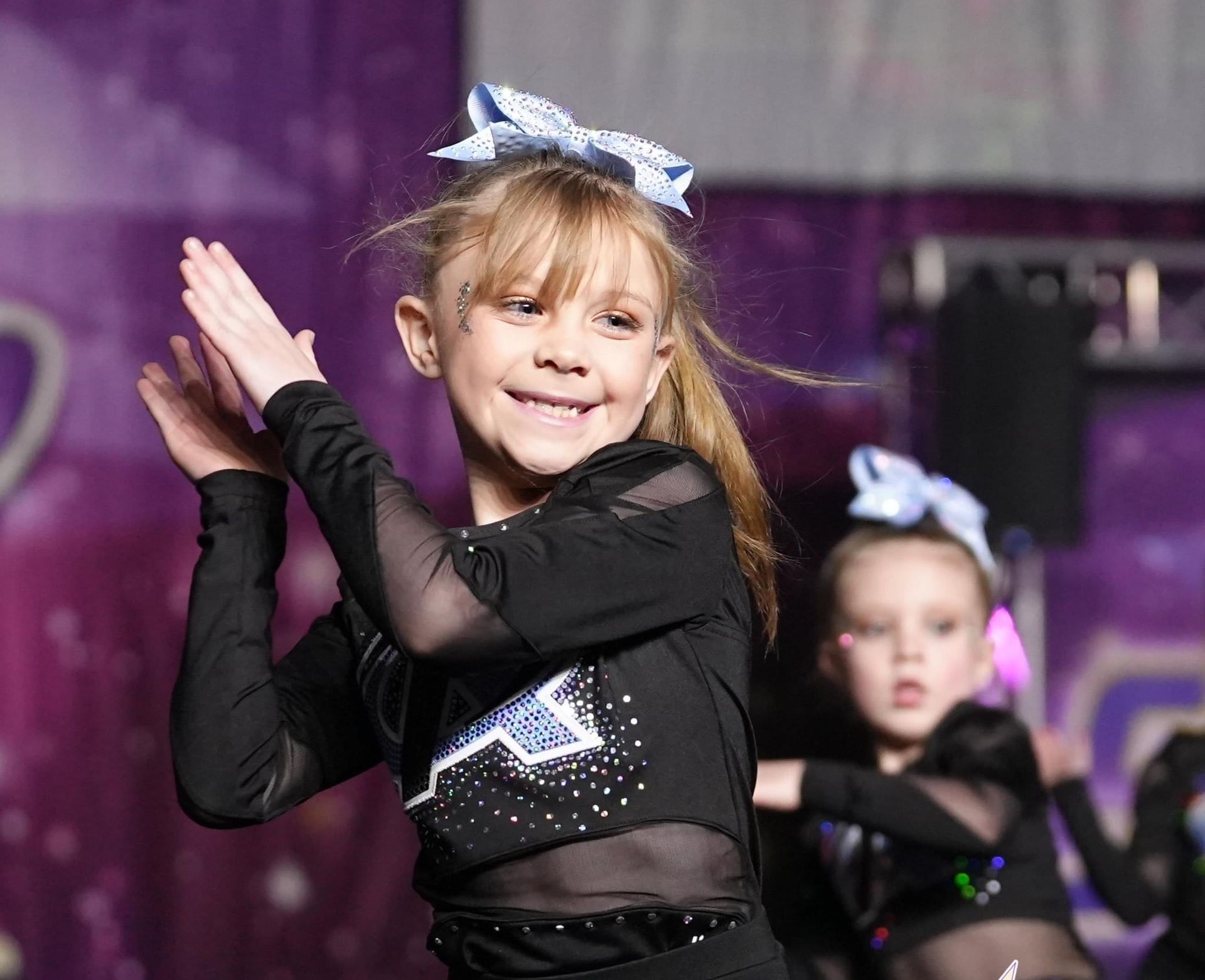 A group of young girls are dancing on a stage.