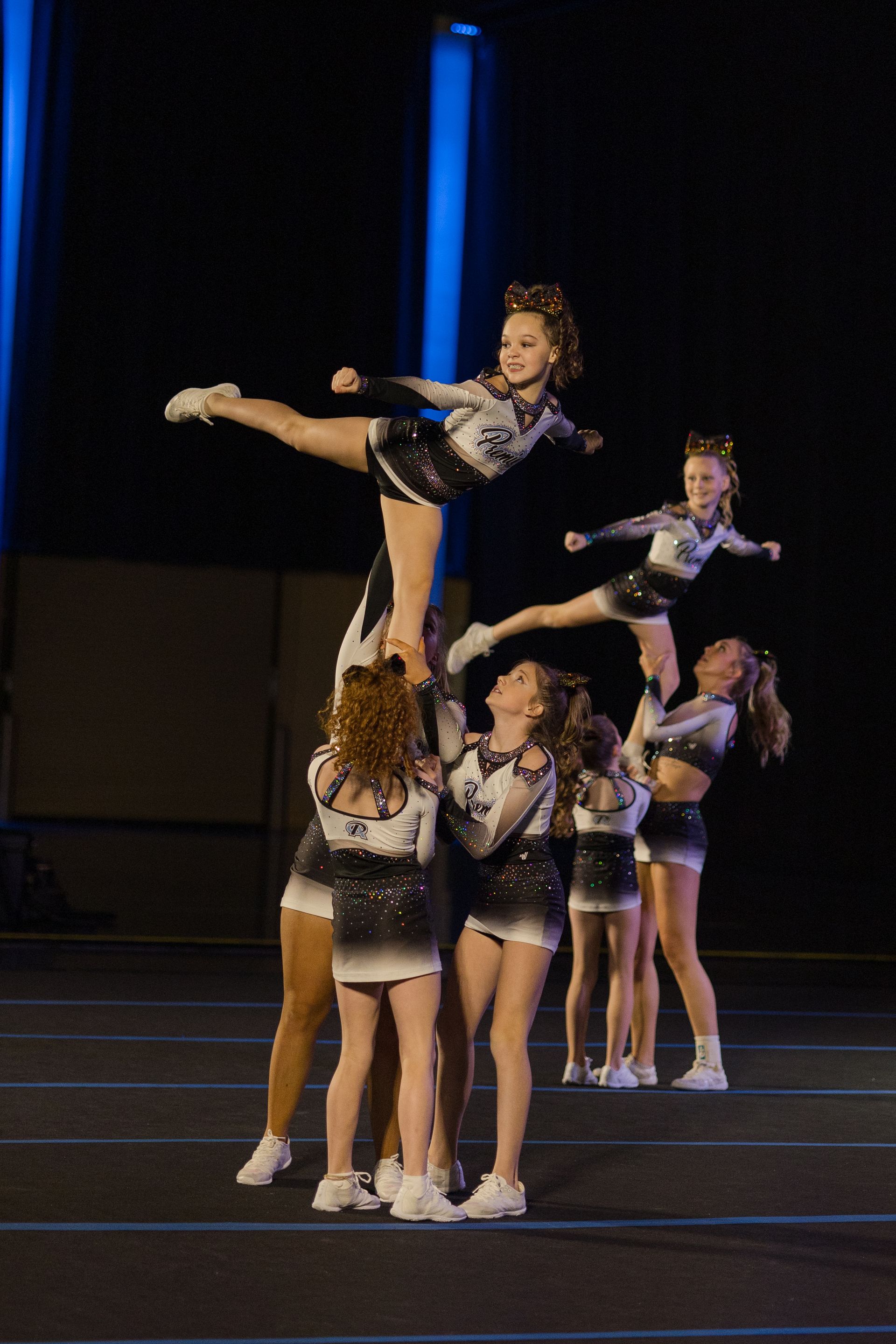 A group of cheerleaders are performing a trick on a stage.