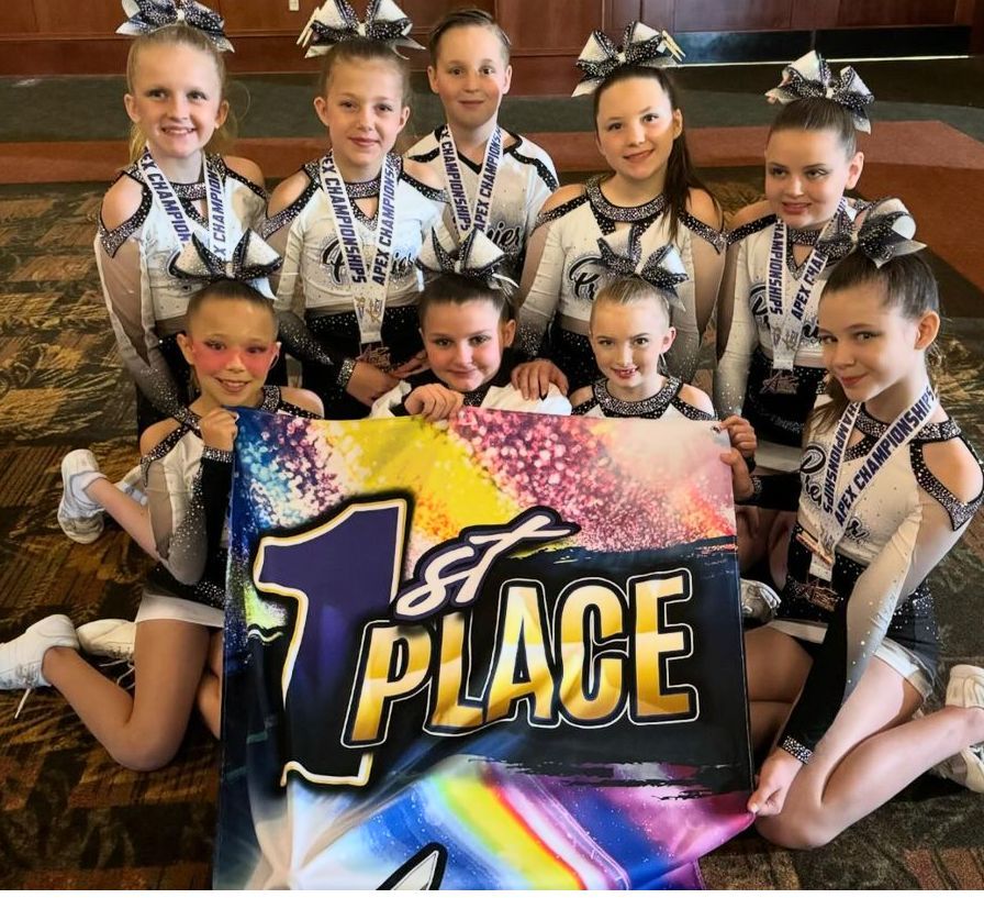 A group of cheerleaders holding a banner that says 1st place