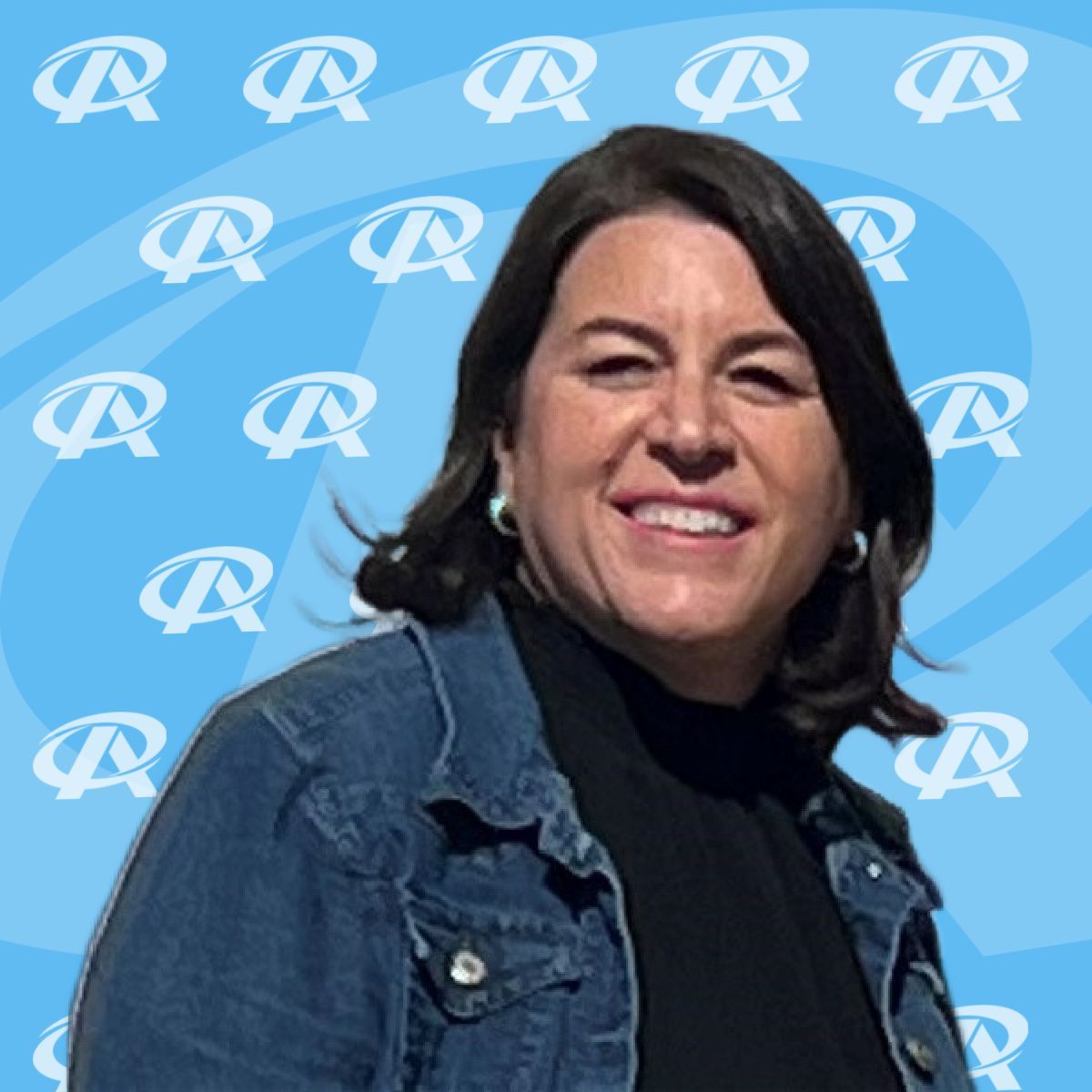 A woman in a denim jacket is smiling in front of a blue background with the letter r on it