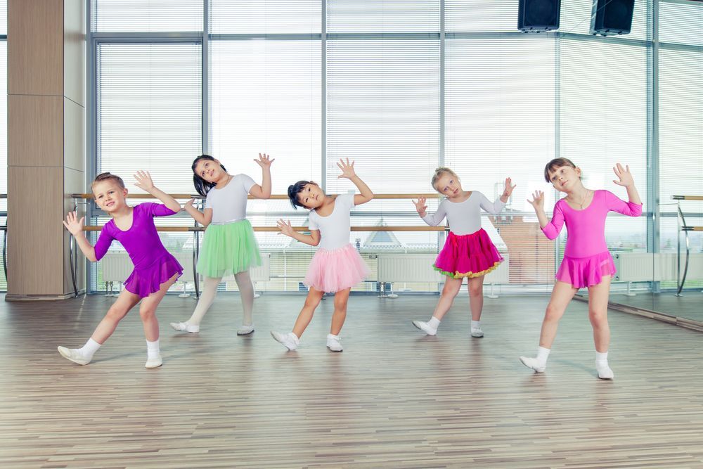 A group of young girls are dancing in a dance studio.