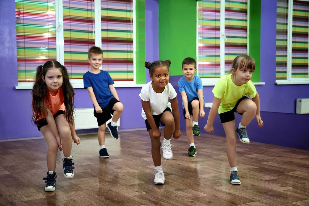 A group of children are doing exercises in a gym.