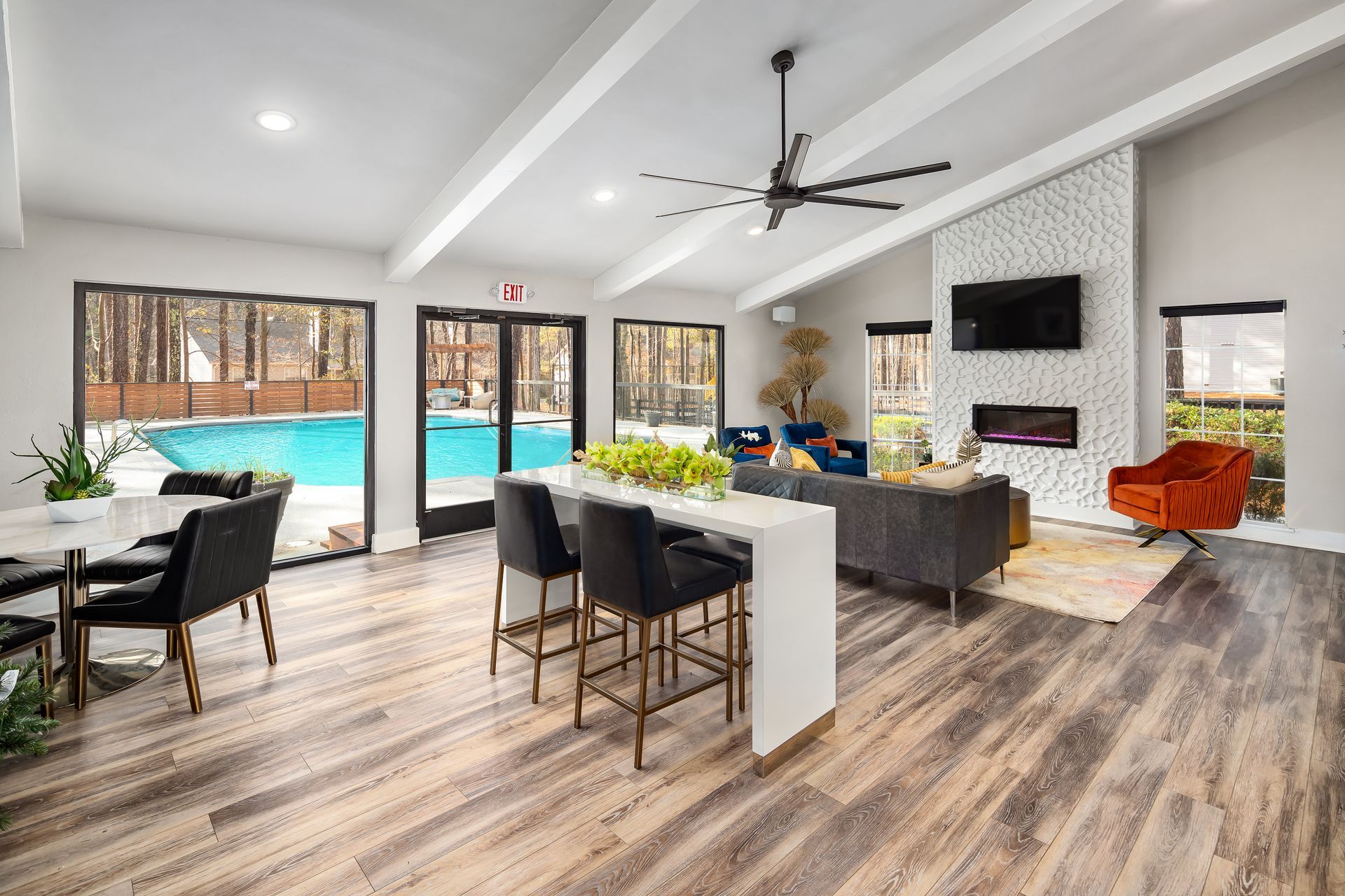 A living room with a dining table , chairs , a fireplace and a ceiling fan.