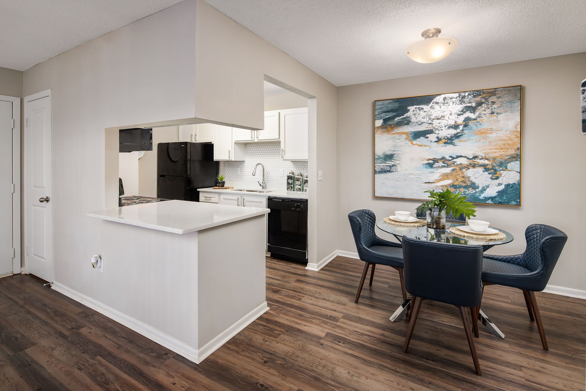 A dining room with a table and chairs next to a kitchen.