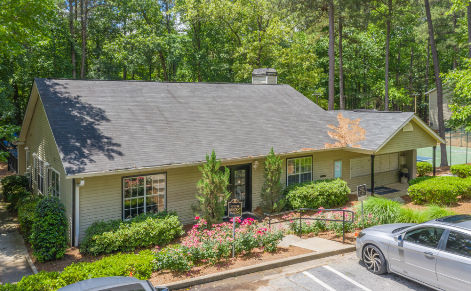 A house with a car parked in front of it surrounded by trees at The Mark at Riverdale.