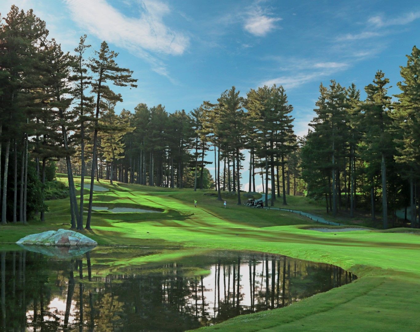 A golf course with a pond in the middle of it