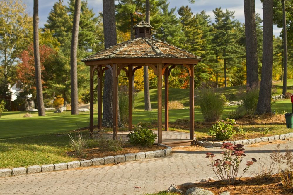 A gazebo in the middle of a park surrounded by trees