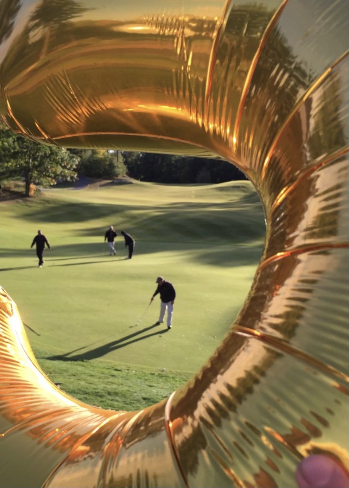 A group of people are playing golf on a golf course