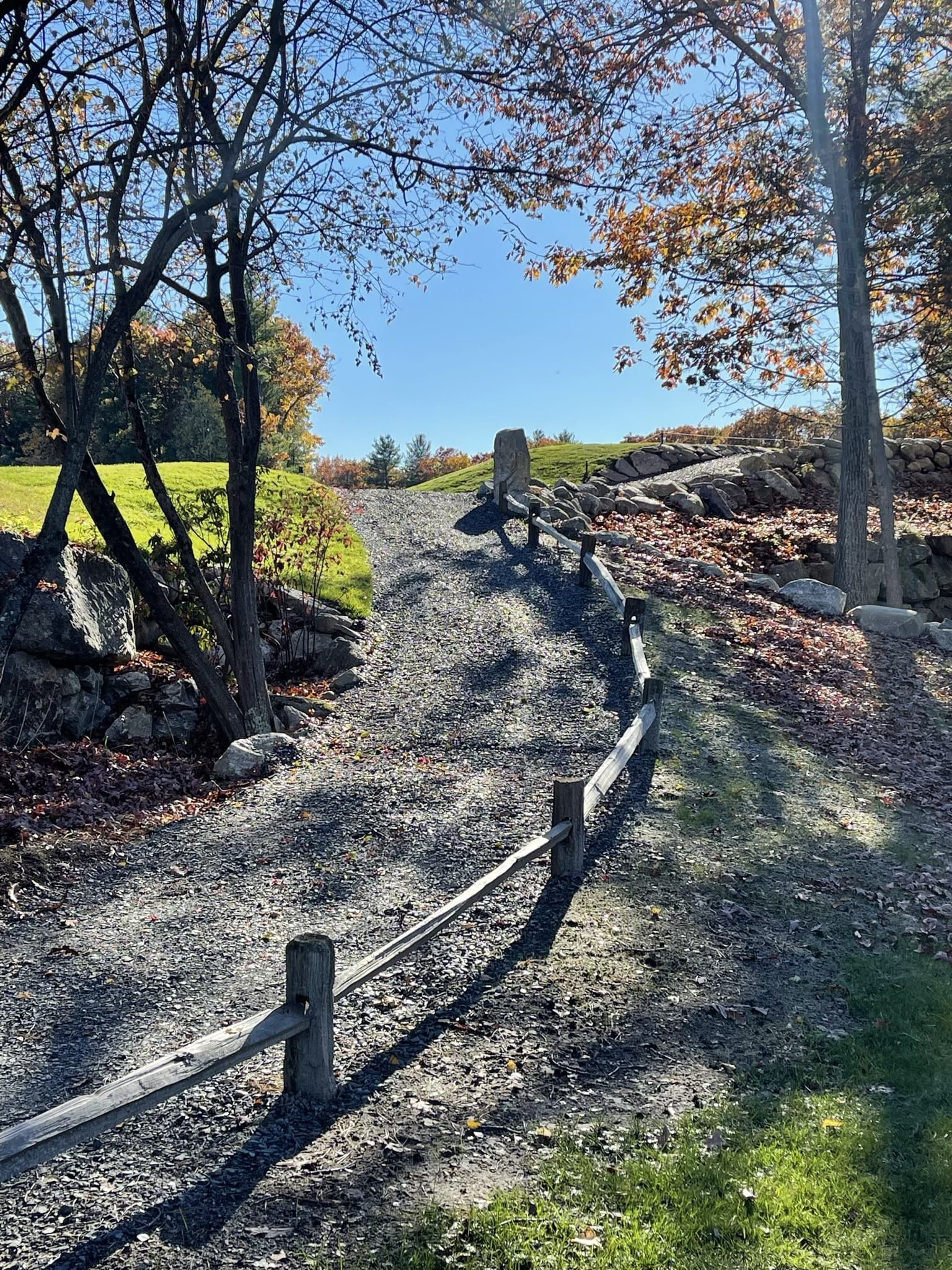 There is a wooden fence along the side of the road.