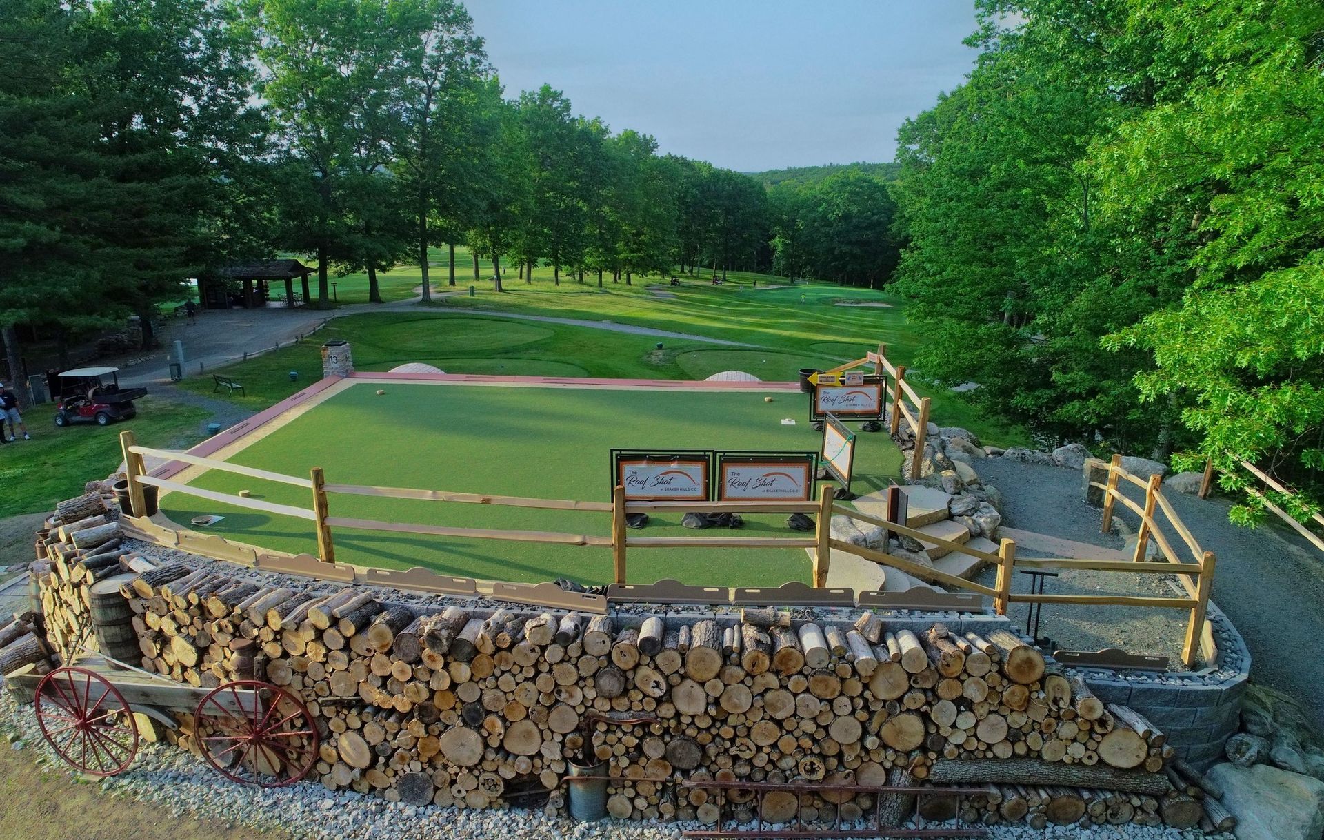 An aerial view of a golf course with trees in the background