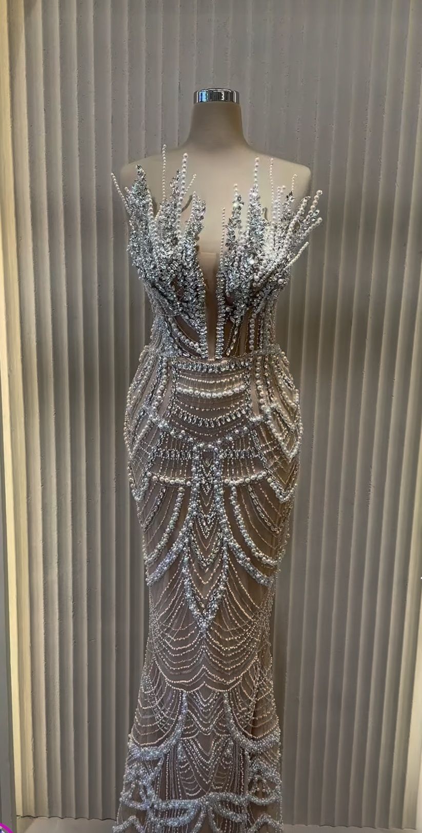 Twee vrouwen in roze jurken met grote strikken, met pakketjes in hun handen, lachend, in een roze winkel met gouden accenten.