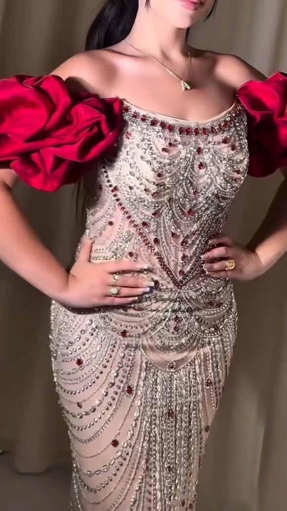 Nude gala- of feestjurk met rode, glinsterende steentjesdetails.