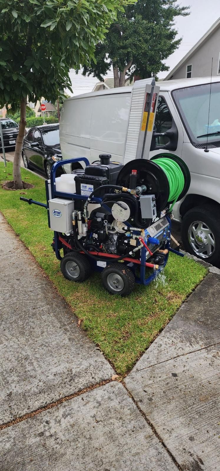 A Machine is Parked on the Side of the Road Next to a Van