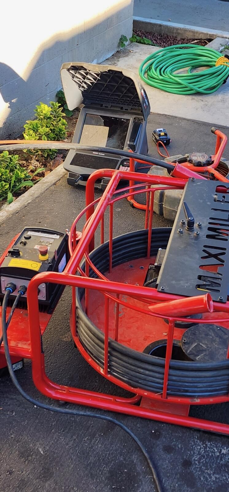 A Drain Camera is Sitting on the Ground Next to a Hose