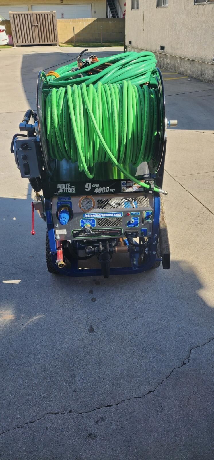 A Jeep With a Green Tarp on Top of It is Parked on the Side of the Road