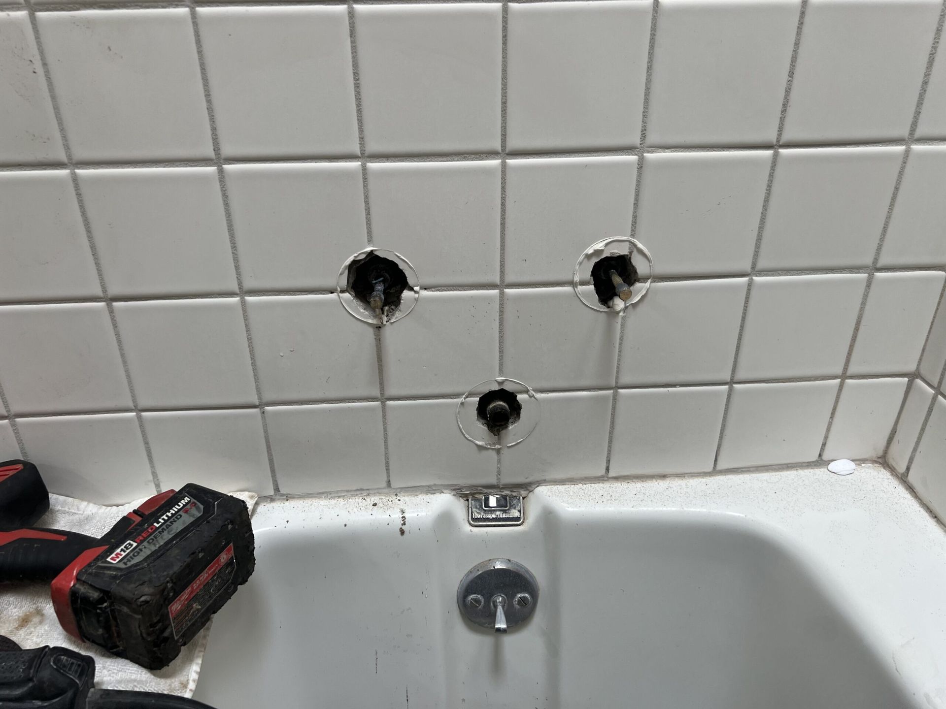 A Bathtub is Being Remodeled in a Bathroom With Holes in the Tiles