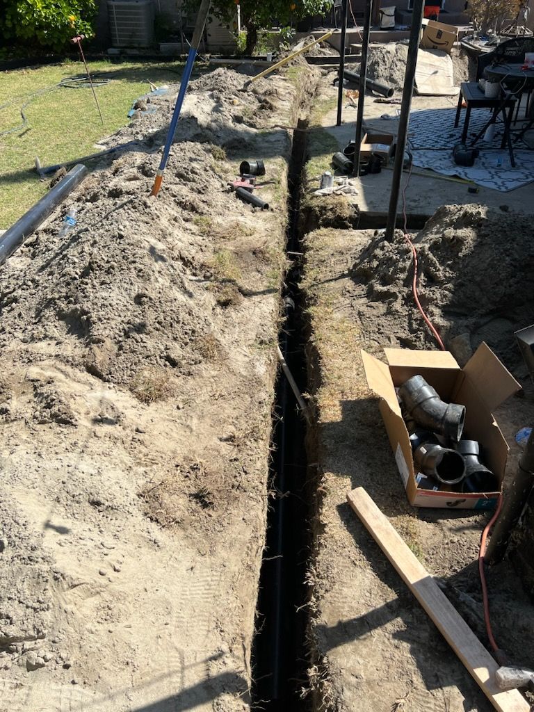 A Box of Pipes is Sitting in the Dirt Next to a Hole in the Ground