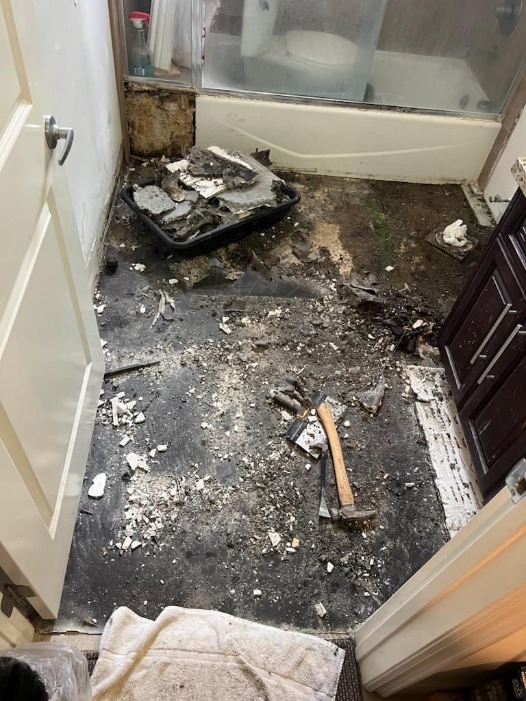 A Bathroom With a Bathtub and a Hammer on the Floor