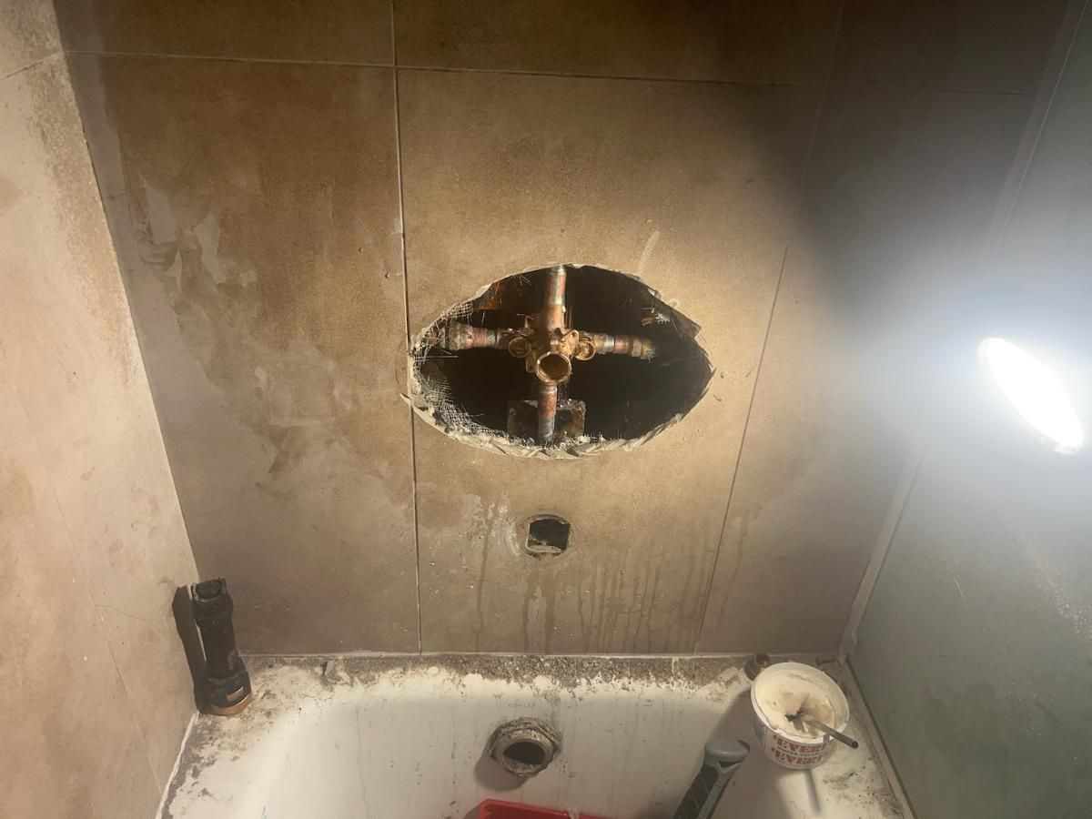 A Bathroom With a Hole in the Wall and a Bathtub