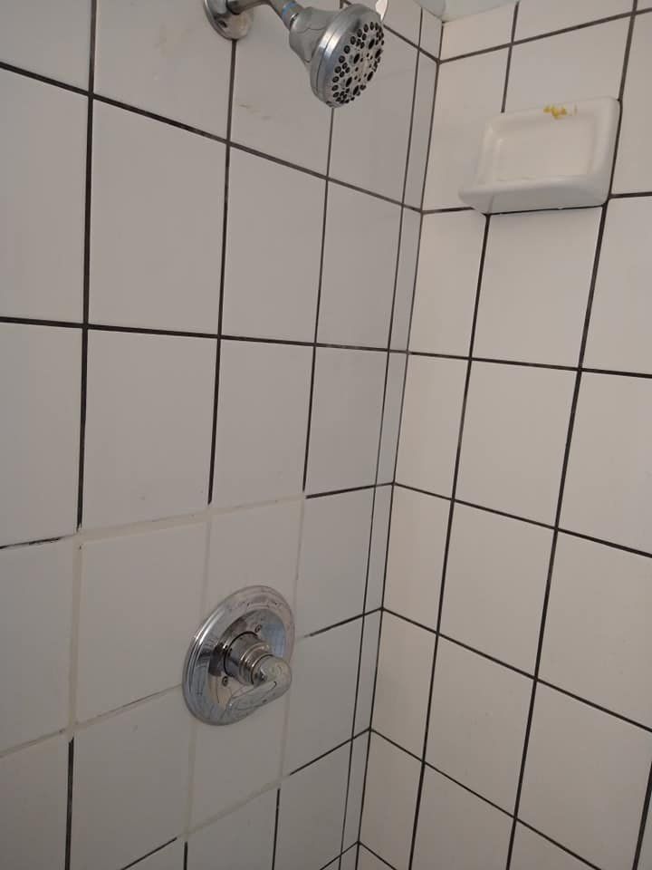 A Shower With White Tiles and a Shower Head