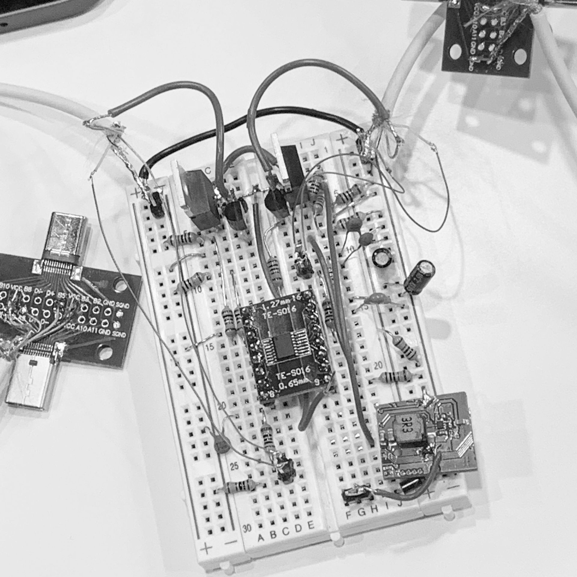 A black and white photo of a breadboard with electronics on it.