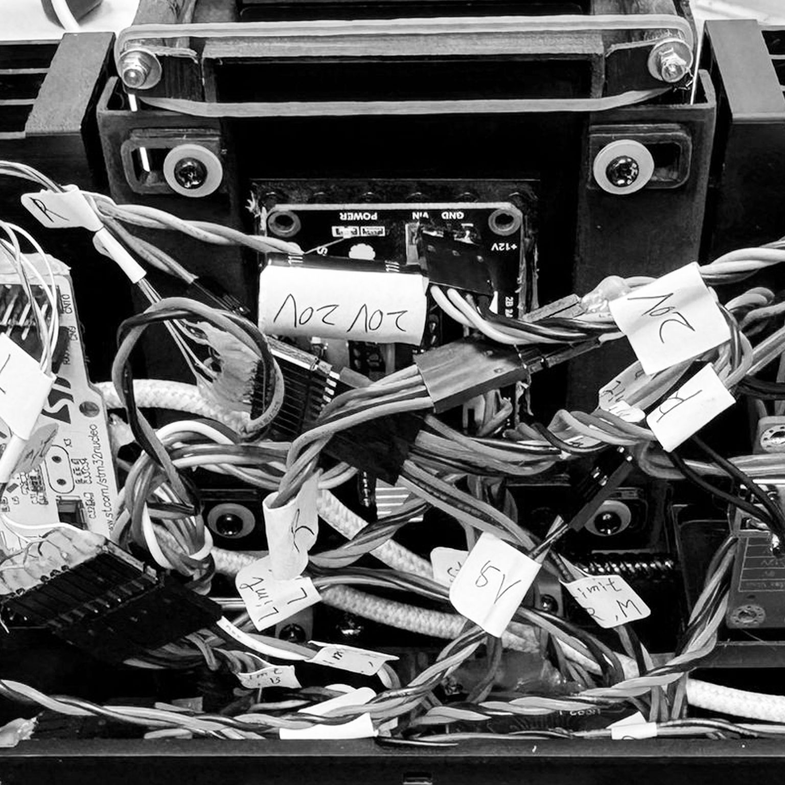 A black and white photo of a computer with a lot of wires coming out of it.
