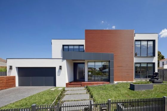 Woman stirring a red pot on a stove in a bright kitchen