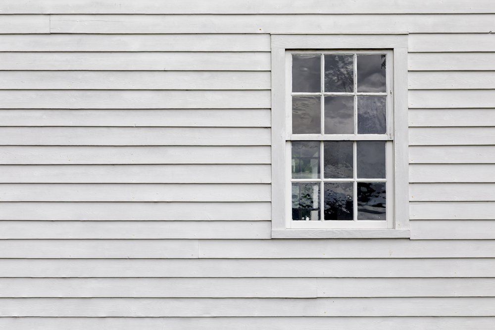 Exterior House Wall with White Wood Siding and a Single Window