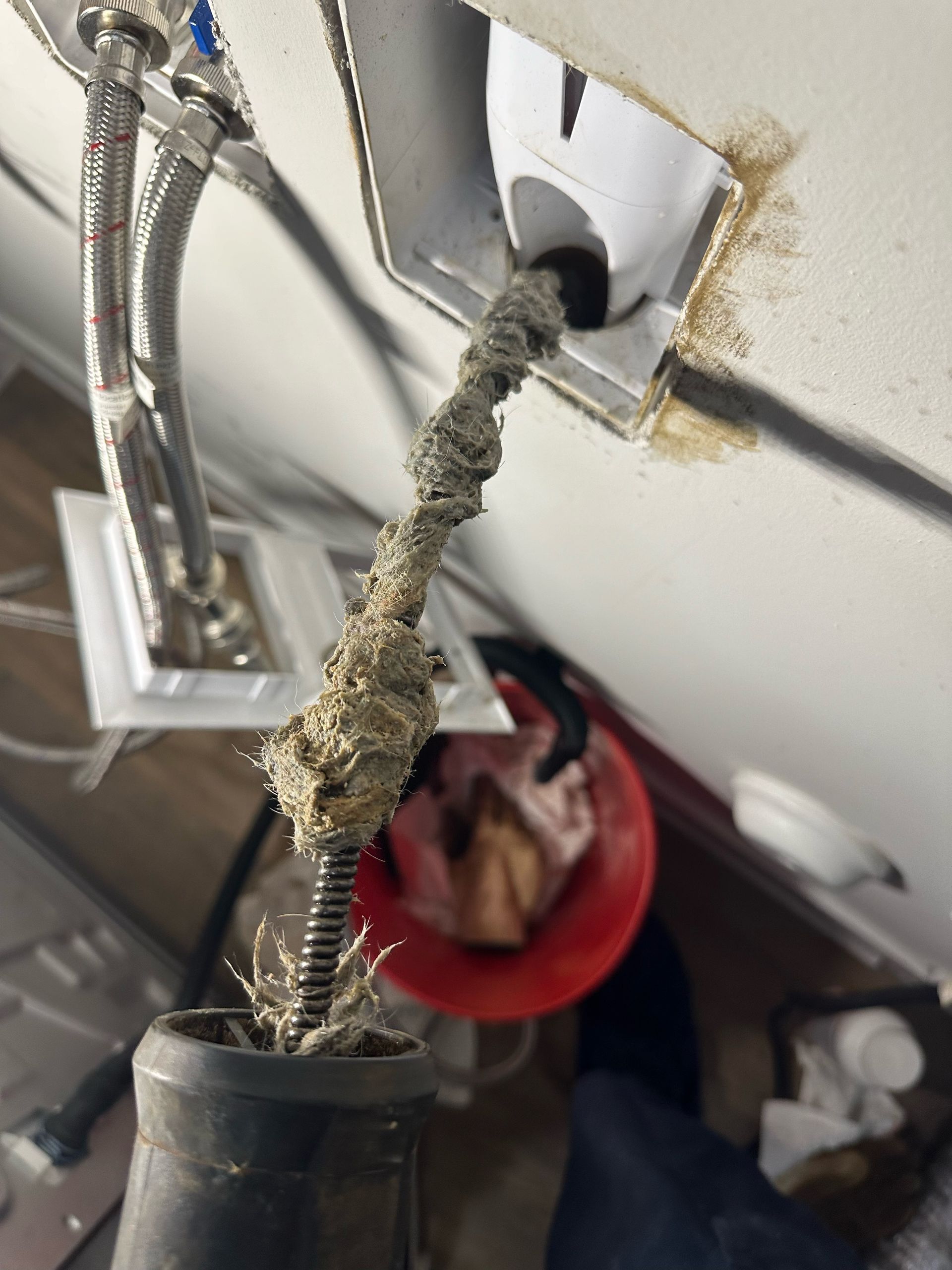 A plumber is fixing a pipe with a wrench.