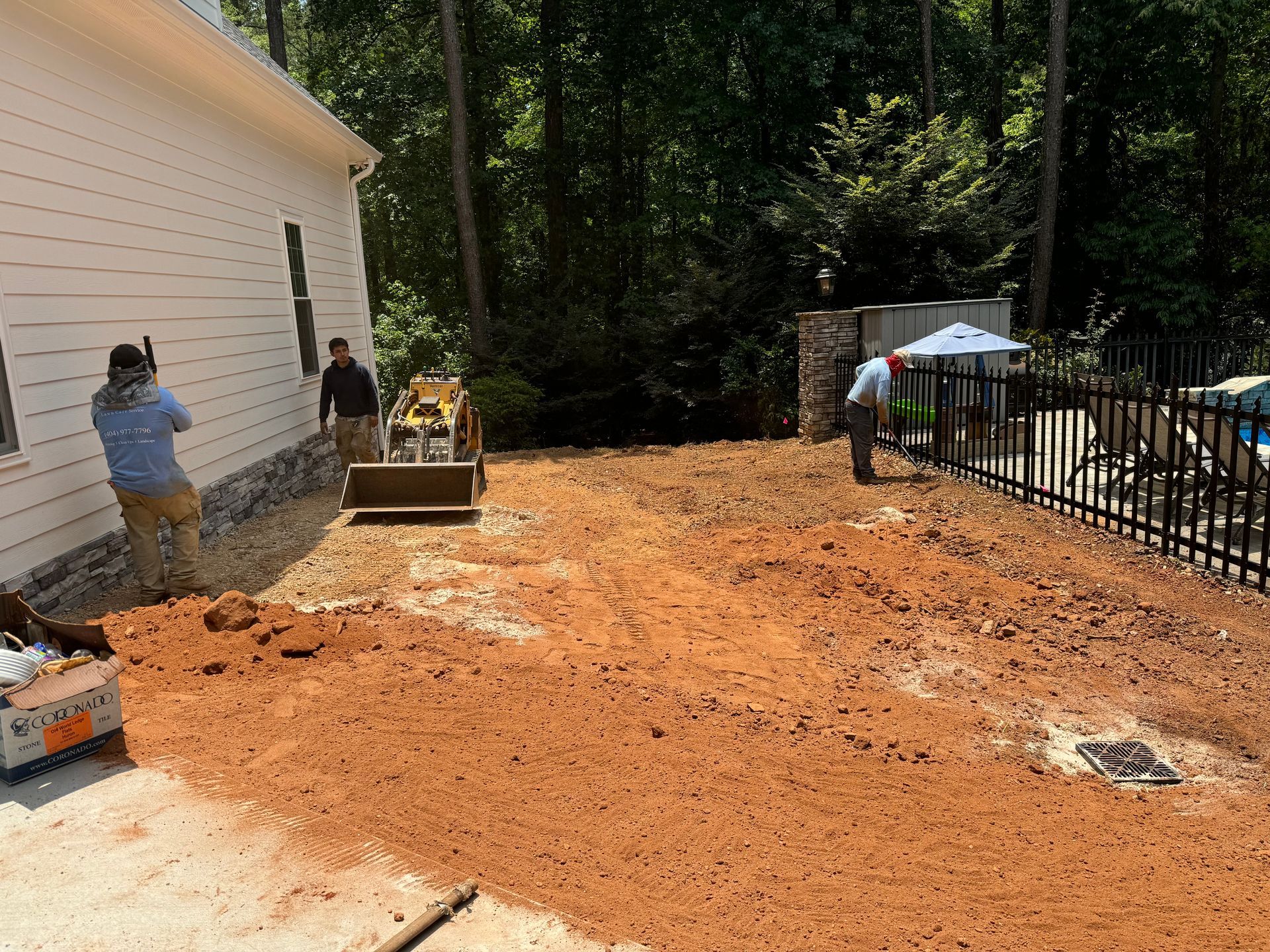 A man is standing in the dirt in front of a house.