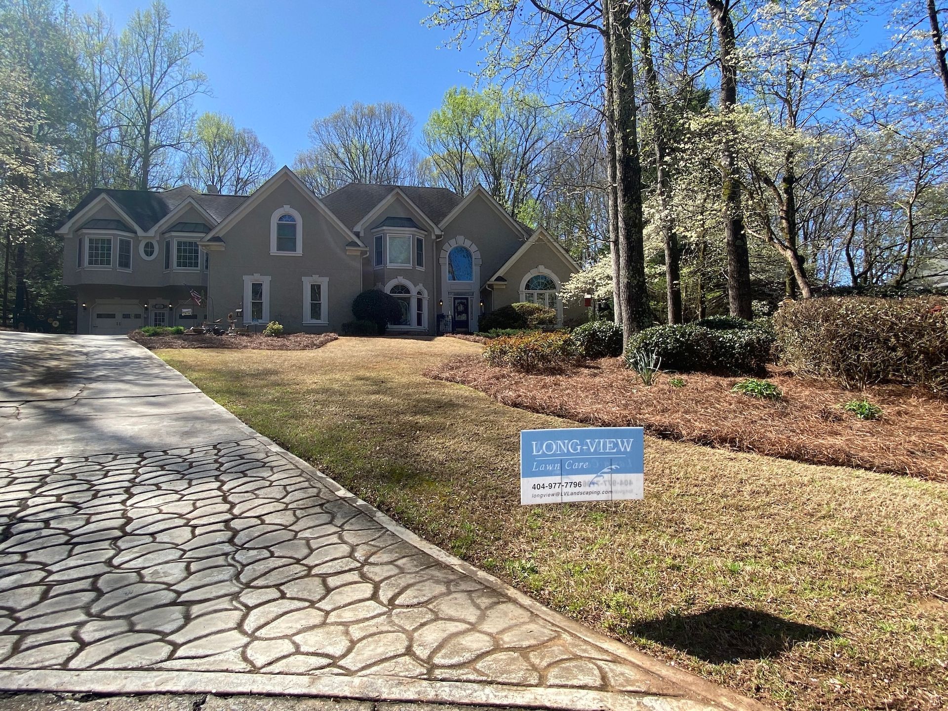 A large house with a for sale sign in front of it.