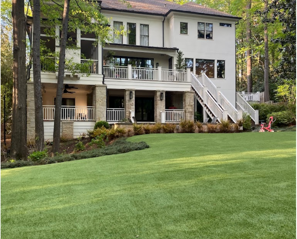 freshly mowed lawn with pruned landscaping in front of a house