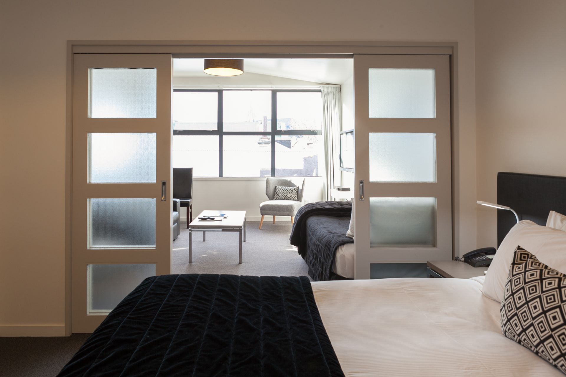 A hotel room with a bed and sliding glass doors