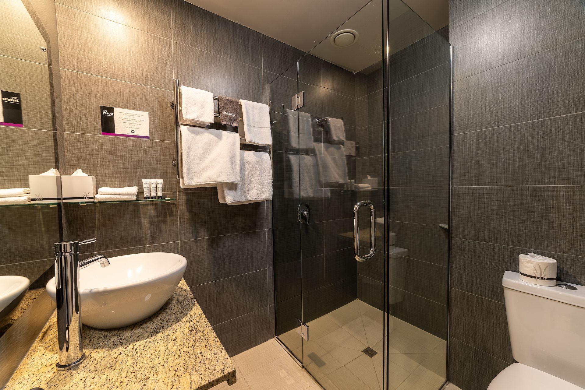 A bathroom with a sink , toilet and walk in shower.