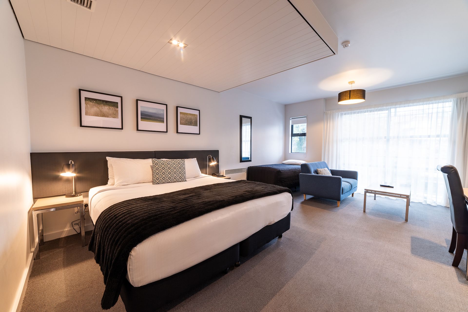 A hotel room with a king size bed and a living room.