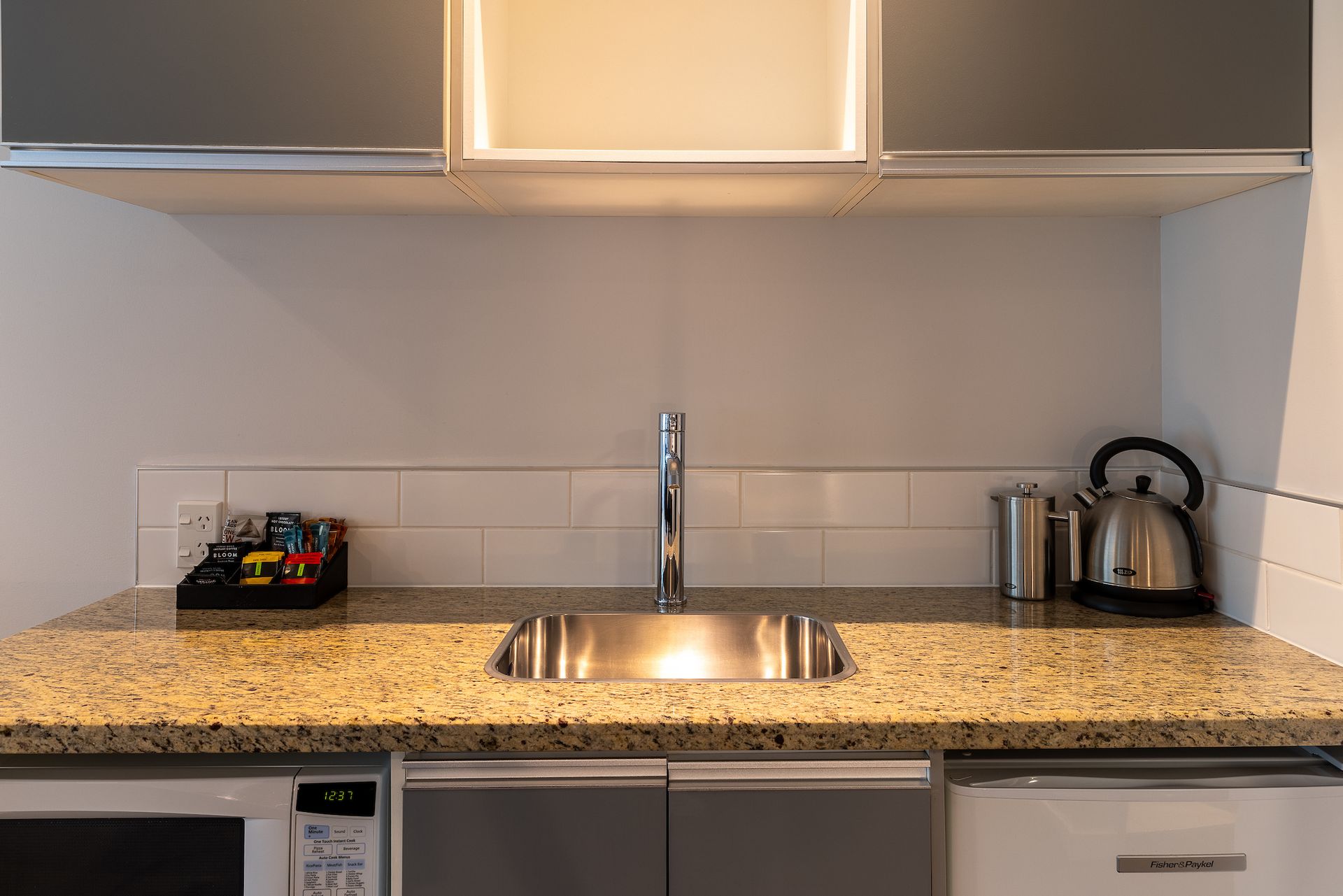 A kitchen with a sink , microwave , and dishwasher.