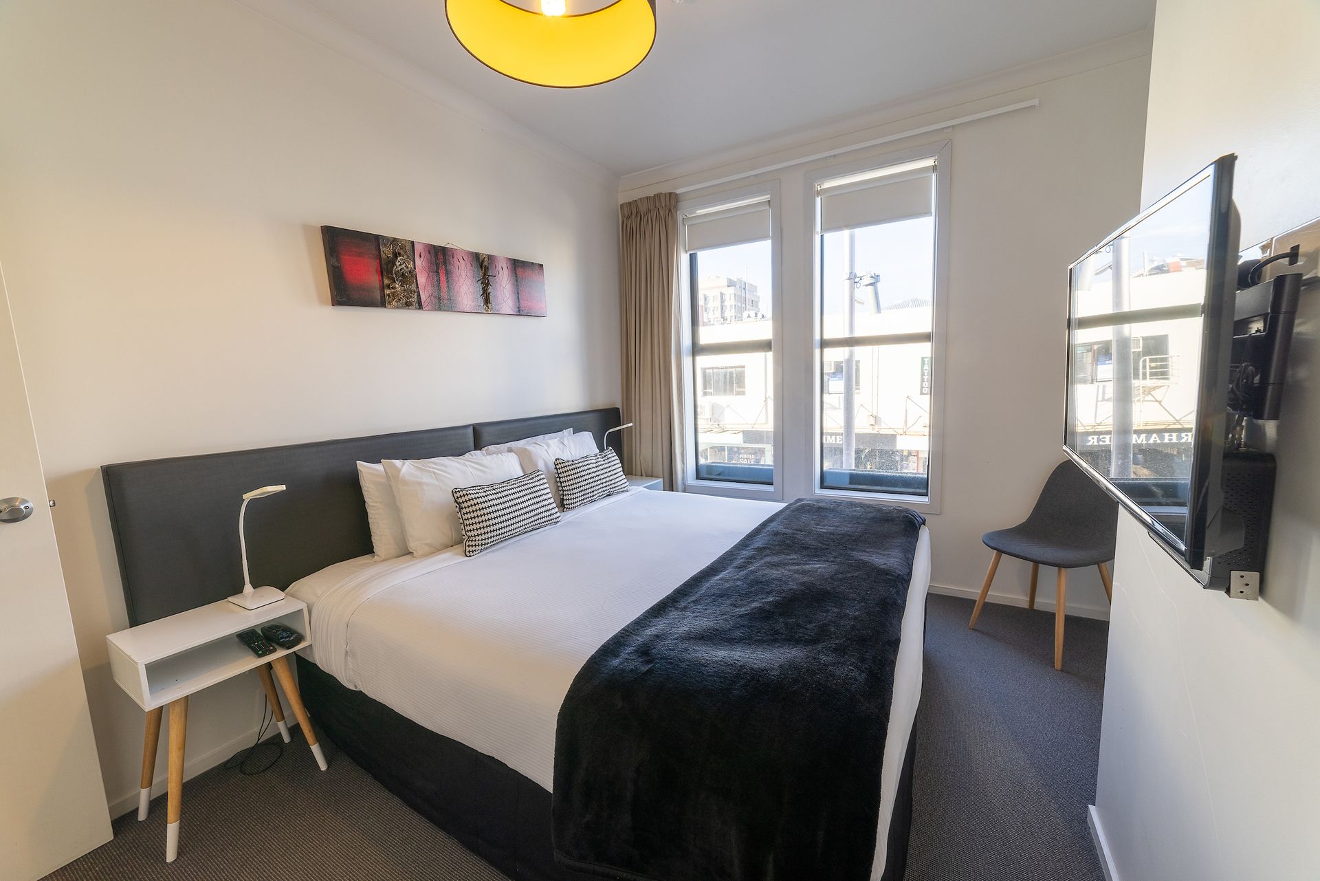 A hotel room with a king size bed and a flat screen tv.