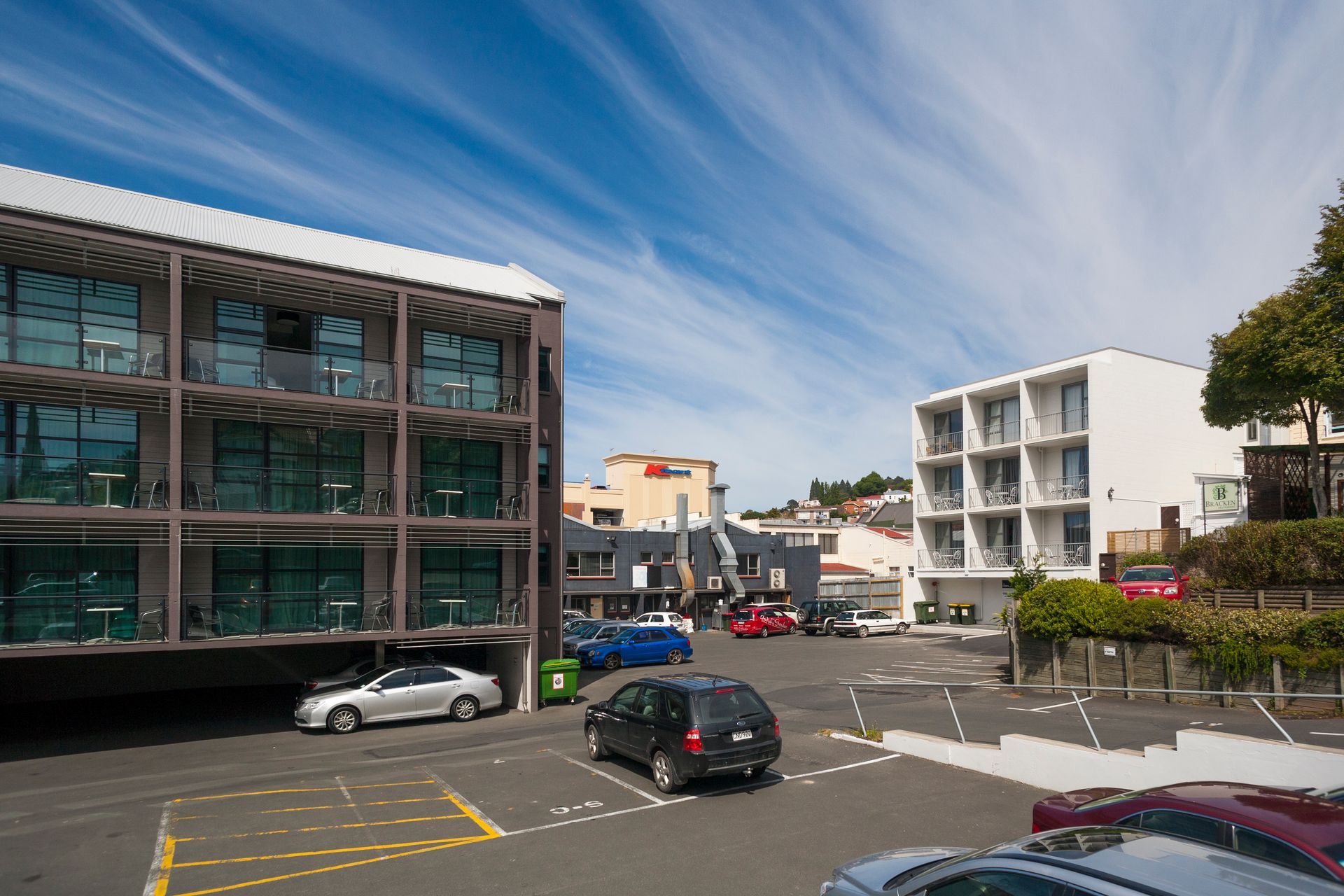 A parking lot with cars parked in front of a building.