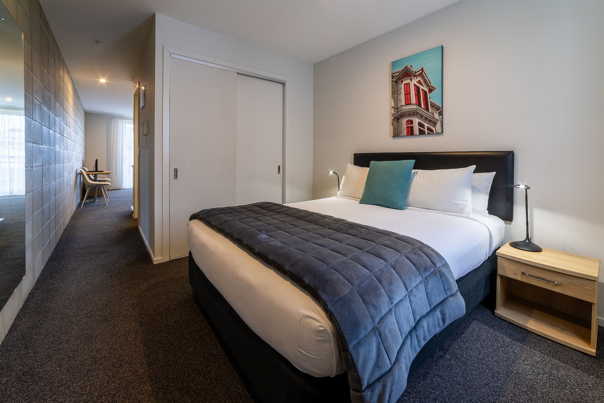 A hotel room with a king size bed and a nightstand.