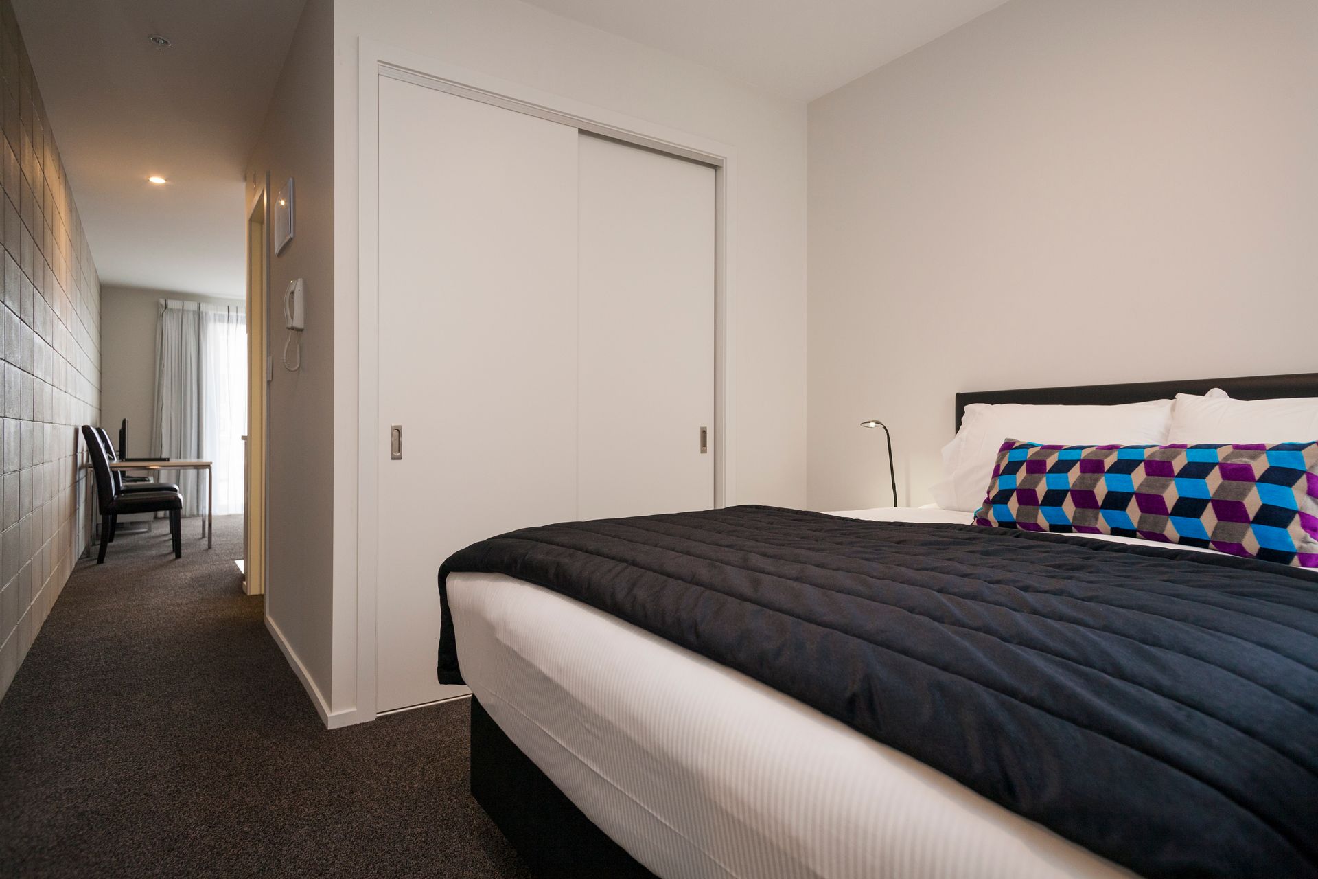 A hotel room with a king size bed and a closet.