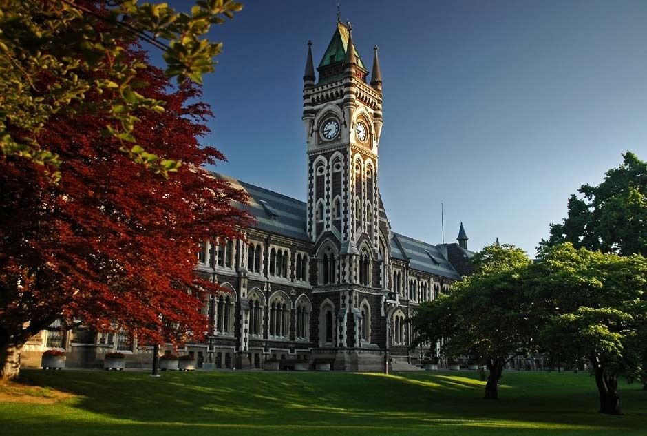 A large building with a clock tower and trees in front of it