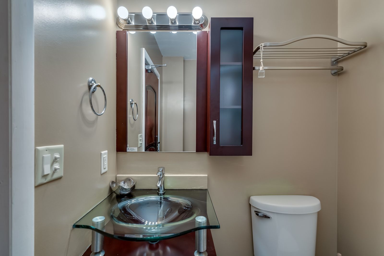 A bathroom with a sink , toilet and mirror.