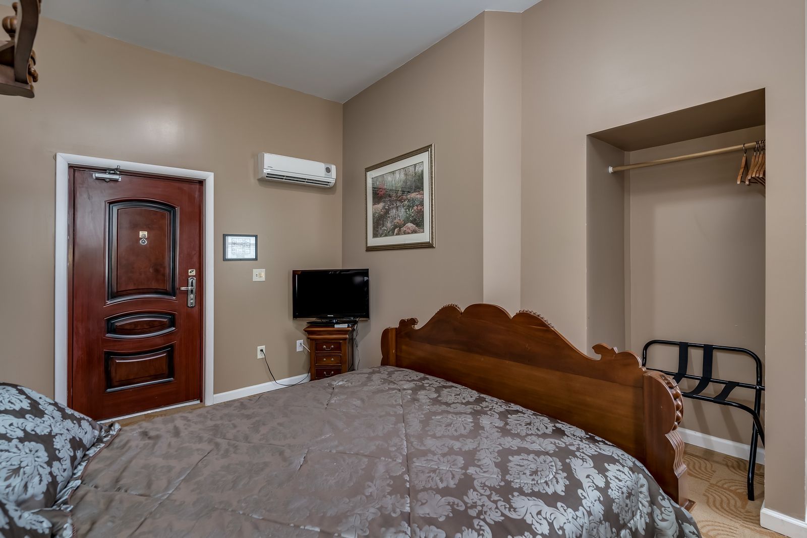 A hotel room with a king size bed and a flat screen tv.