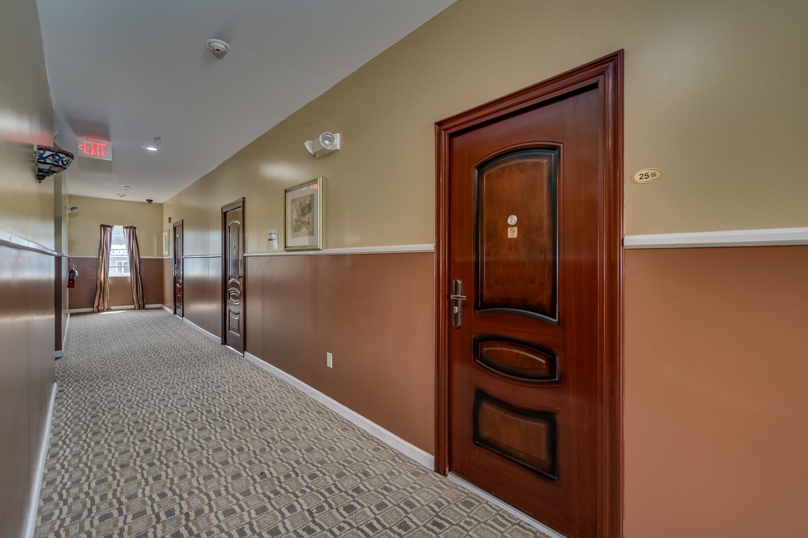 A long hallway with a wooden door in the middle.