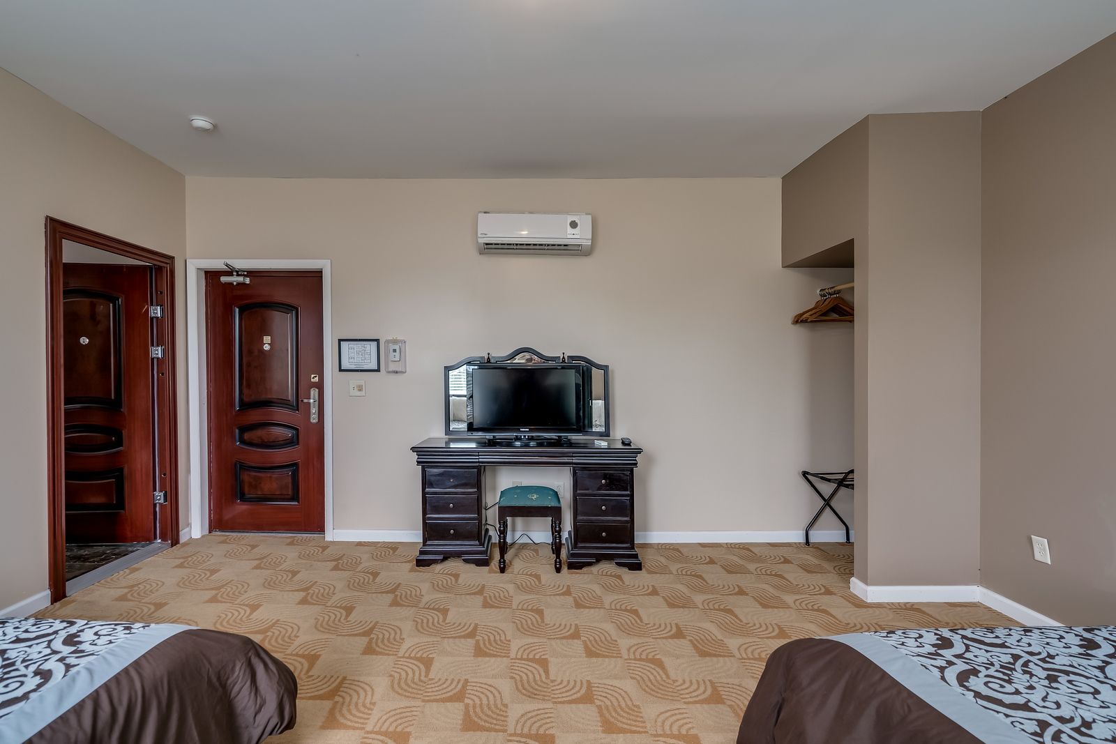 A hotel room with two beds , a desk and a television.