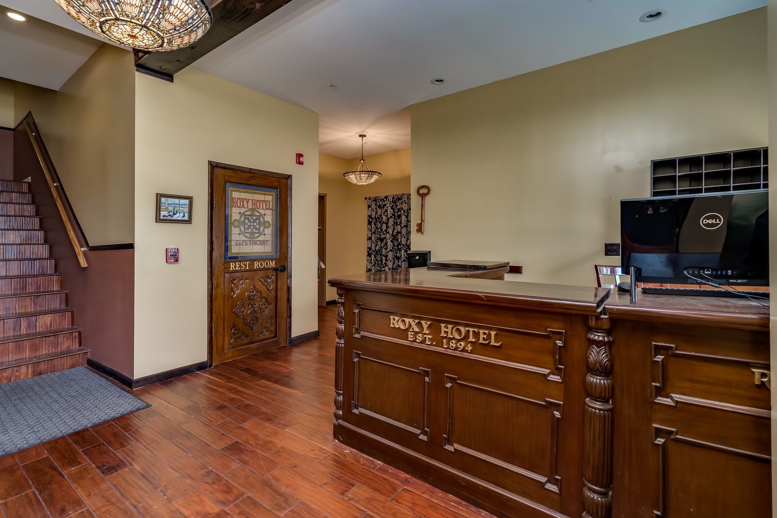 A hotel lobby with a wooden counter and stairs